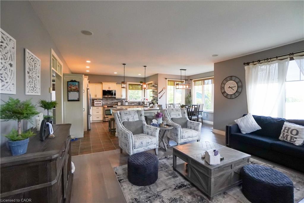 Living area featuring wood-finish flooring, recessed lighting, and a window with white drapery