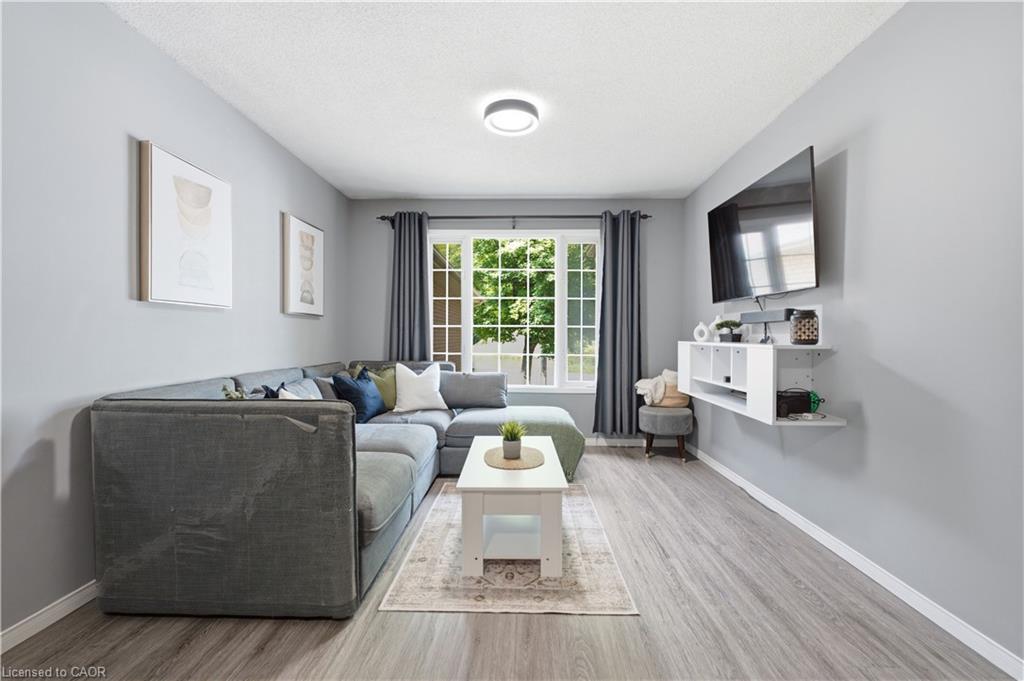 Recessed ceiling lighting, light gray wall paint, wood-finish flooring, white window trim, built-in shelving