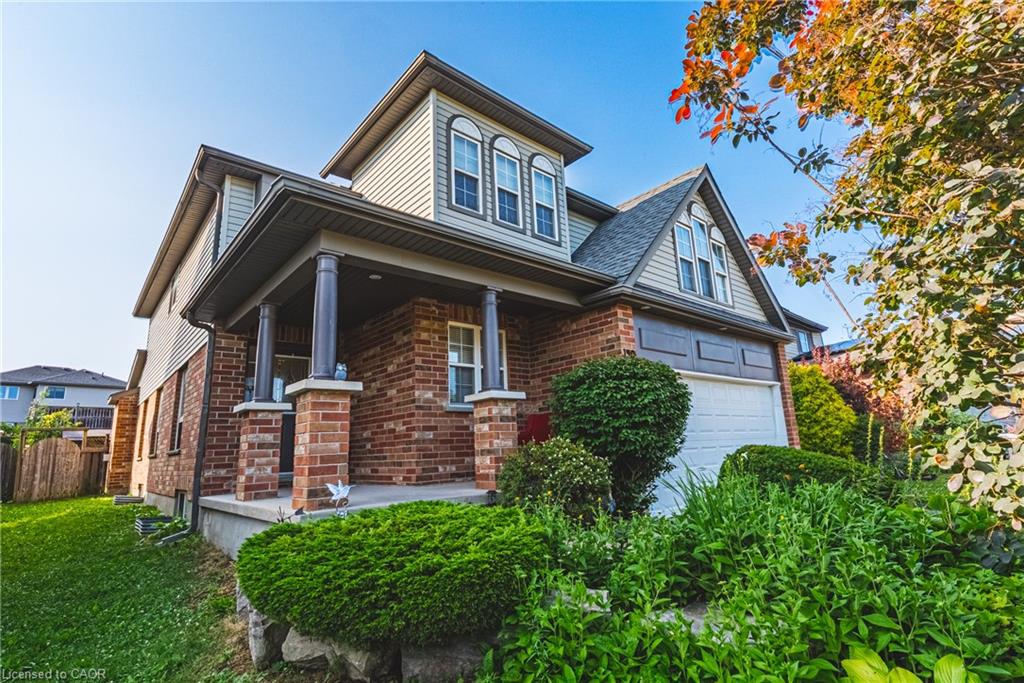 Brick and siding exterior featuring a covered front porch with substantial columns