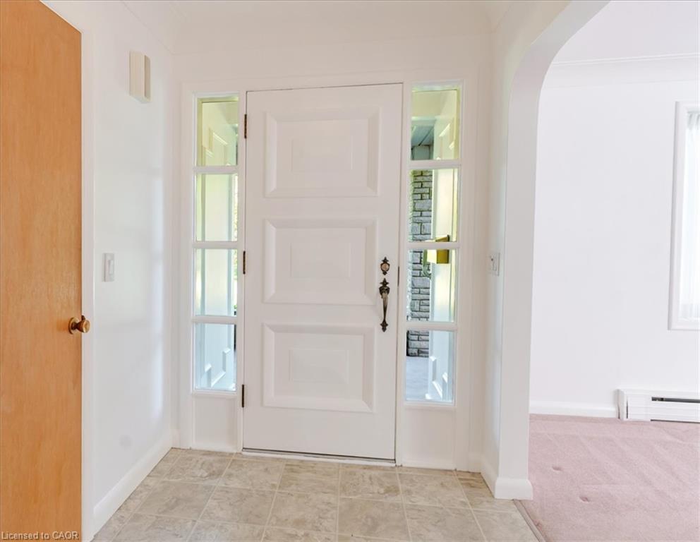 Foyer with the original 3 panel front door and sidelights on either side, plus a front closet for coats and shoes