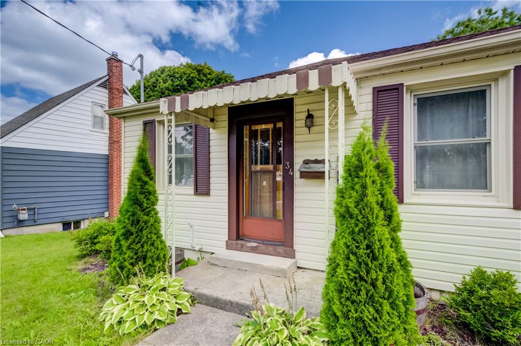 Cream-colored siding, brown window shutters, and a front entry door with decorative glass