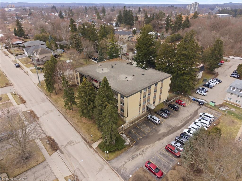 Multi-story building featuring exterior balconies, a flat roof, and an expansive paved parking area