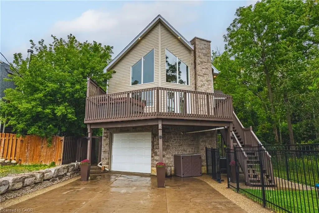 Stone facade exterior with integrated garage, upper-level balcony, and exterior staircase