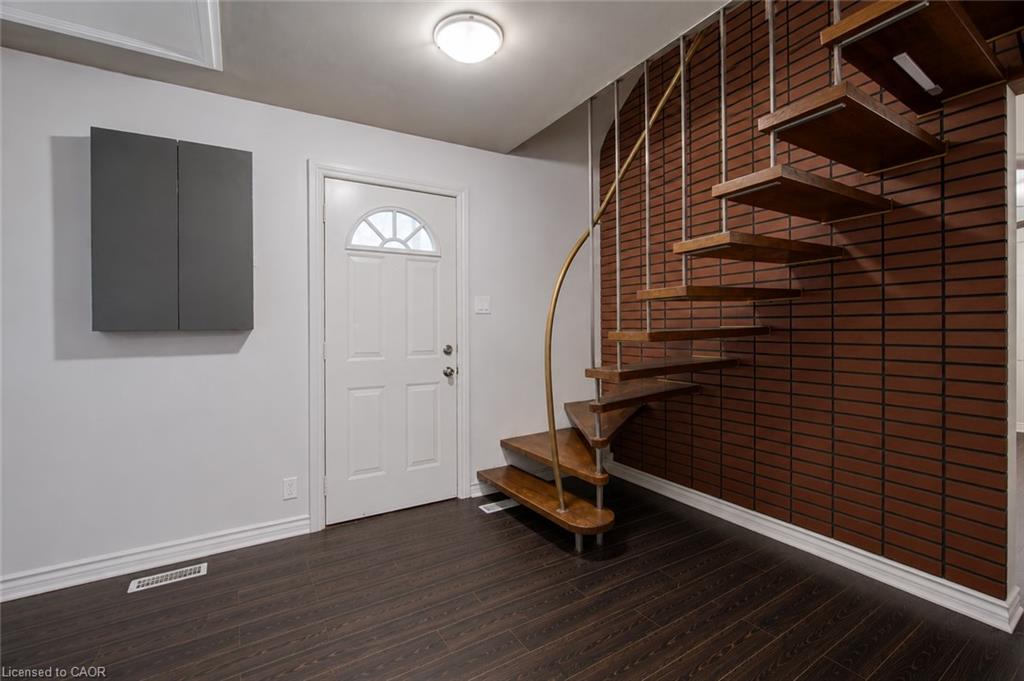 Dark wood-finish flooring with white baseboards