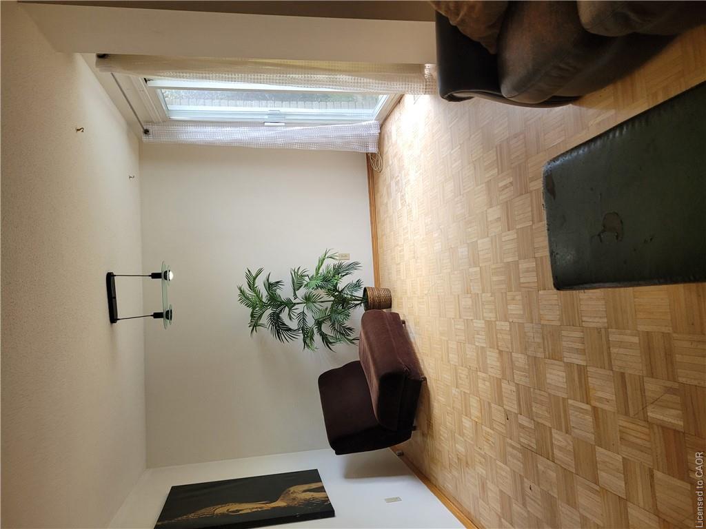 Parquet wood-finish flooring, sliding glass door to exterior, and a modern ceiling light fixture