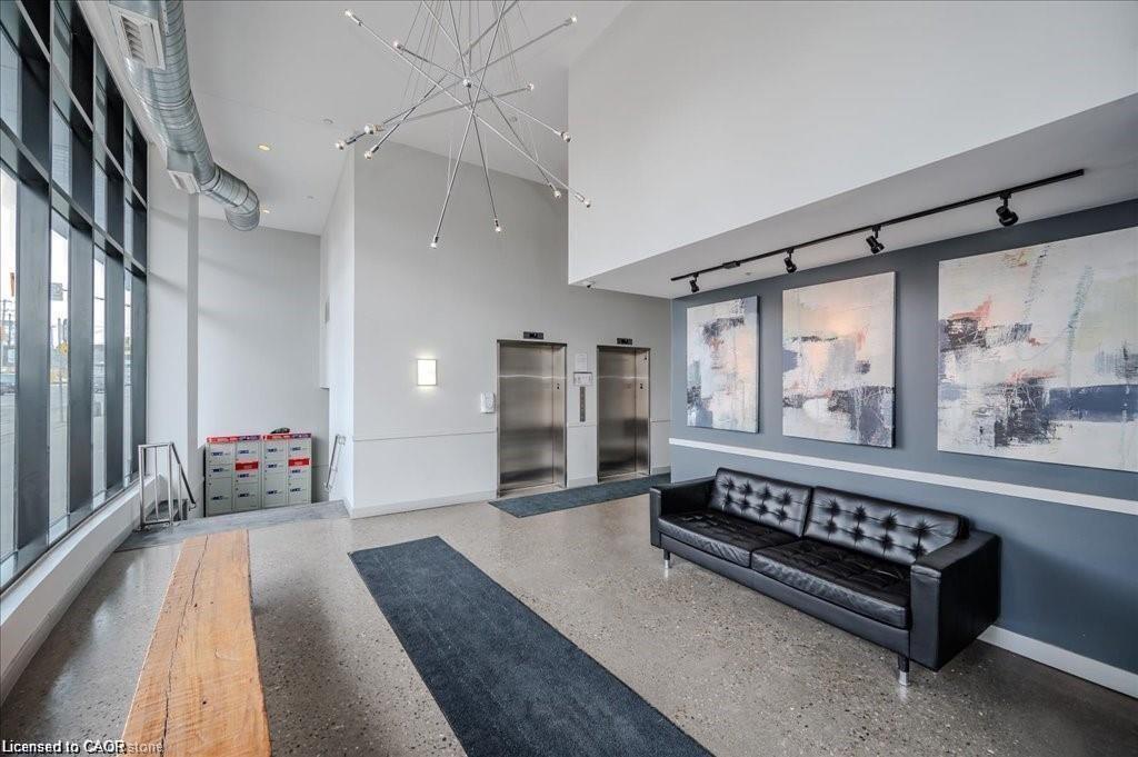 Spacious lobby featuring polished concrete flooring, soaring ceilings, and a striking contemporary chandelier