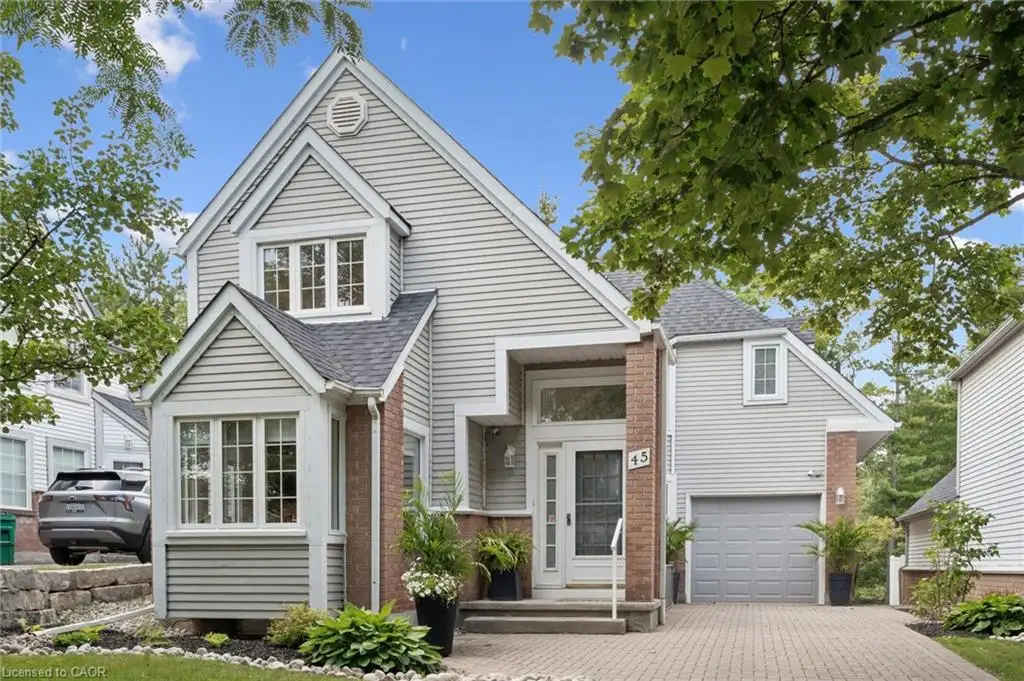 Traditional style exterior with horizontal siding, brick accents, multiple gables, a paved driveway, and a front entry with transom window