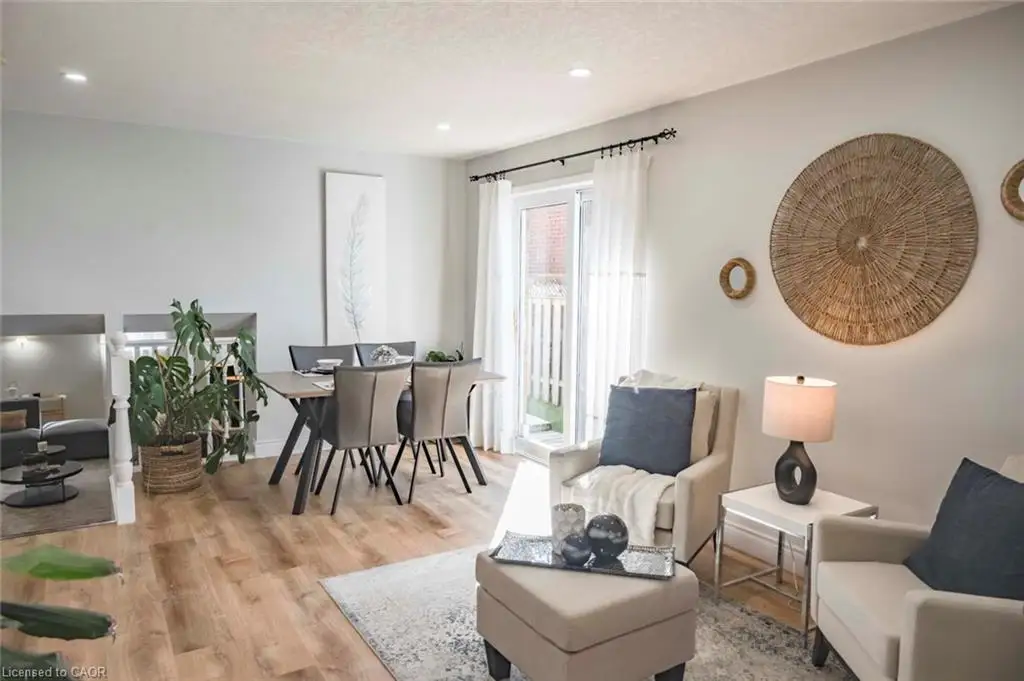 Open-concept living space featuring wood-finish flooring, recessed lighting, and a glass sliding door providing exterior access