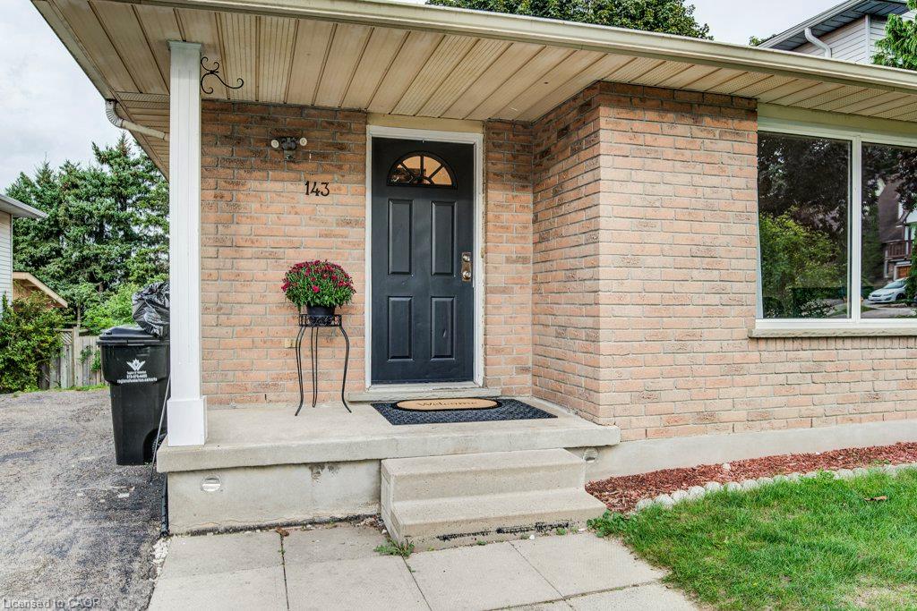 Brick exterior with a covered entryway, front door with an arched window, and a large front window