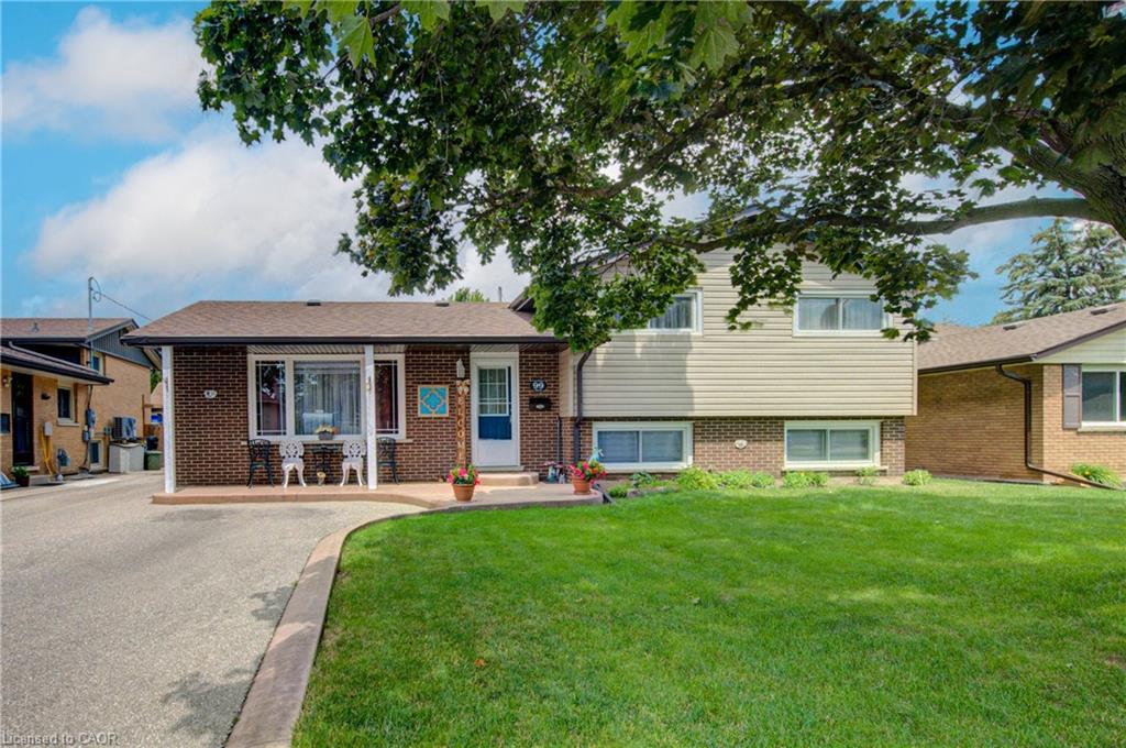Split-level residence featuring brick and siding exterior, a front entry porch, and an attached driveway