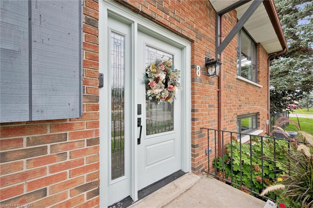 Brick exterior with a light-colored entry door and sidelight