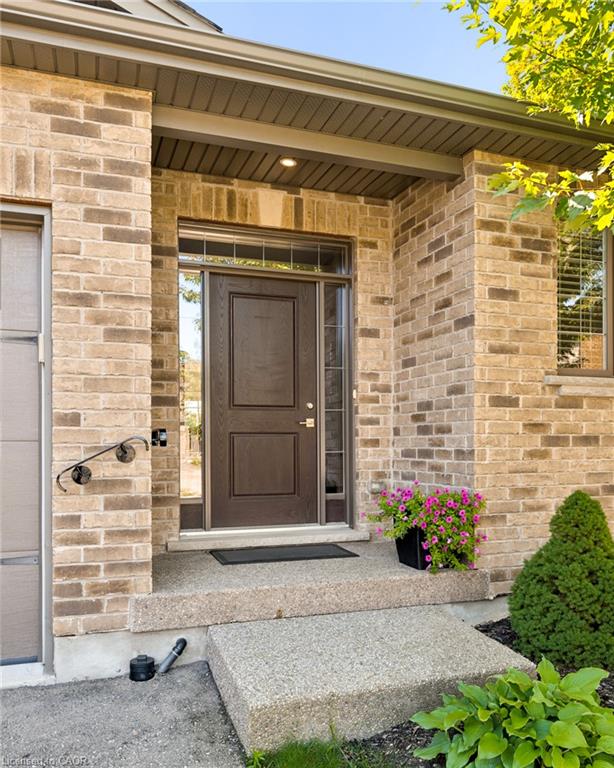 Brick exterior with a prominent brown entry door featuring a transom window