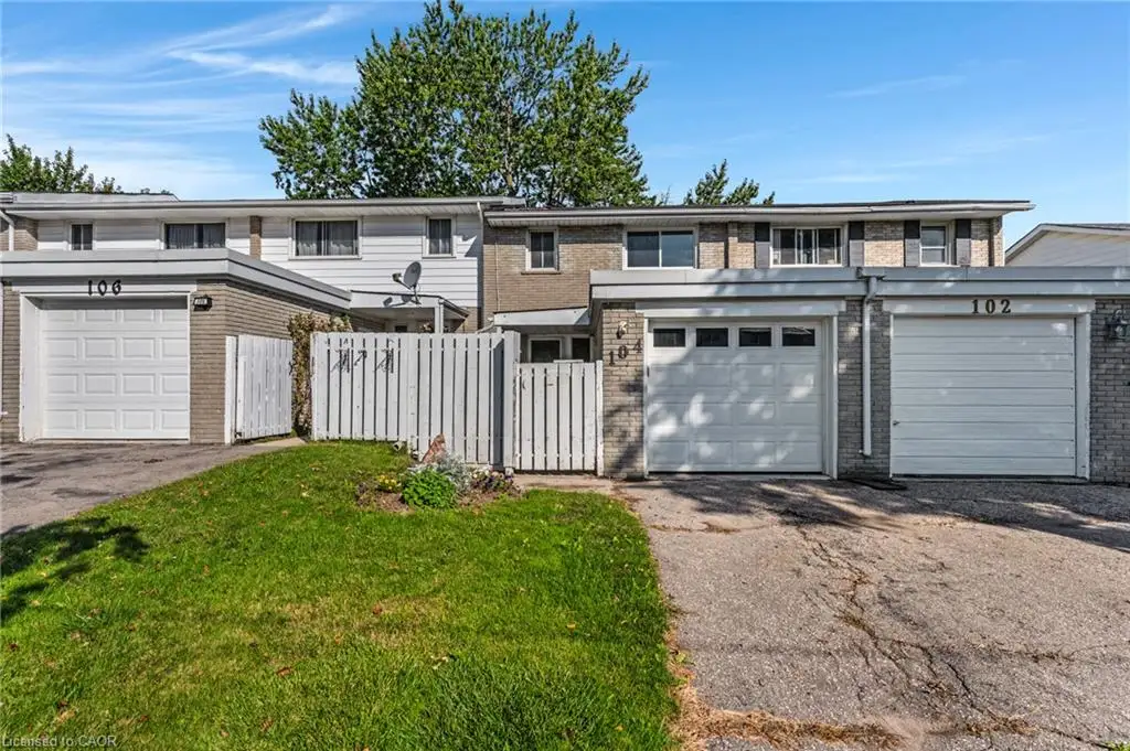 Brick and siding exterior with individual garage doors and partial fencing