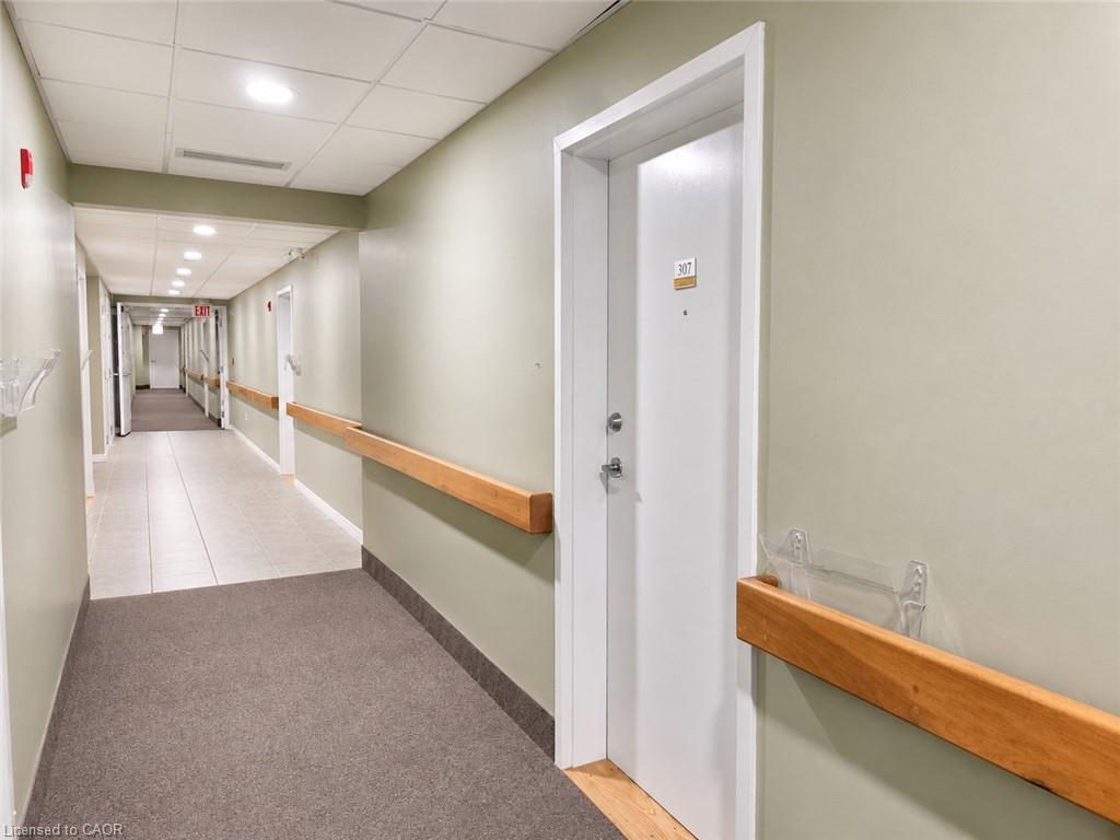 Corridor with light green walls and wood handrails