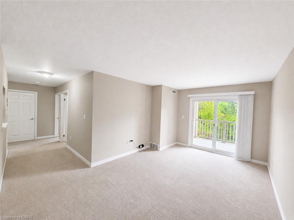 Spacious living area featuring neutral carpeting and light-toned walls