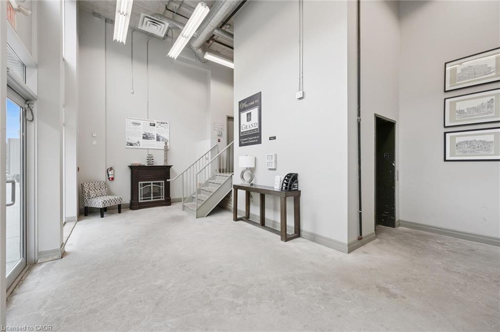 High ceilings, polished concrete flooring, industrial-style lighting, and a prominent staircase with metal railings