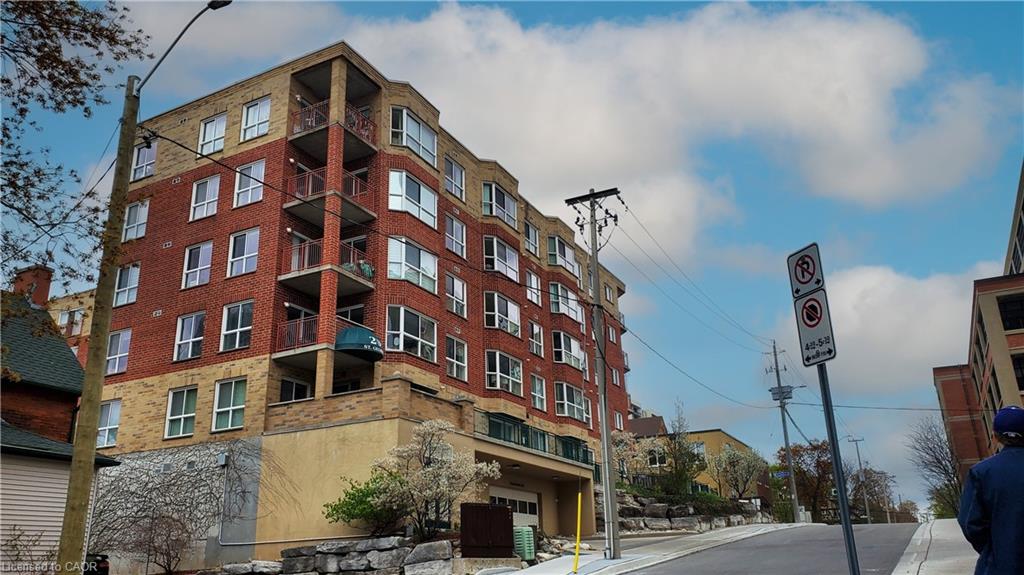 Multi-story residential building featuring red brick and light-colored siding