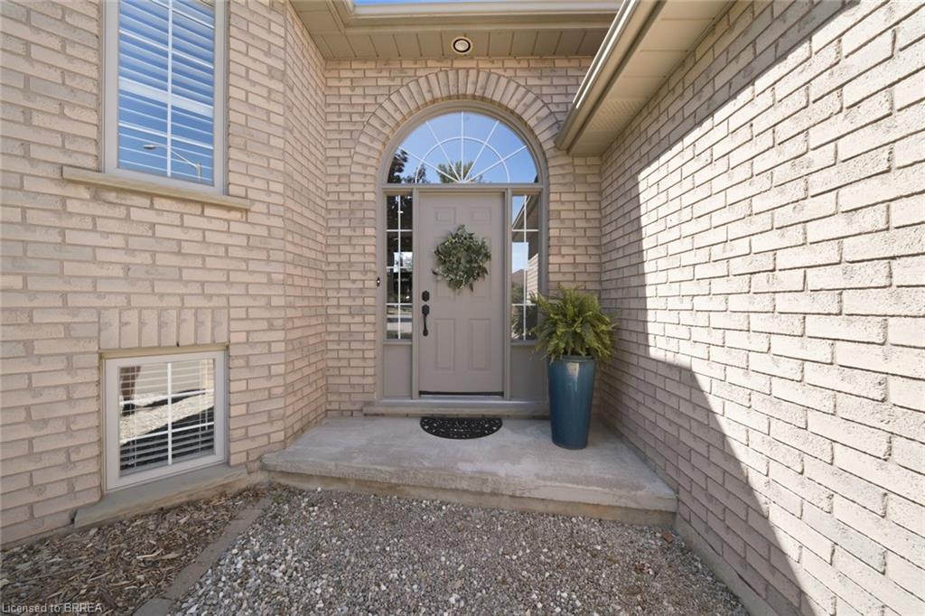 Light-colored brick exterior featuring an arched entryway with a transom window