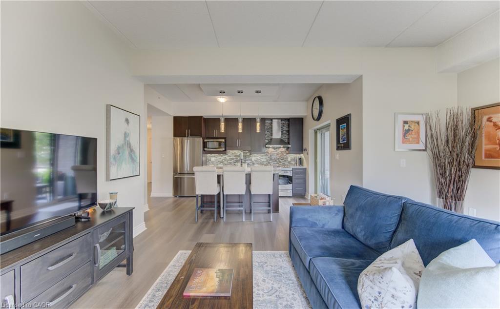 Open concept living space with wood-finish flooring extending into the kitchen
