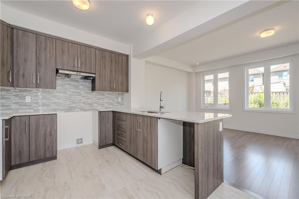Kitchen featuring wood-finish cabinetry, quartz countertops, and an island with a breakfast bar