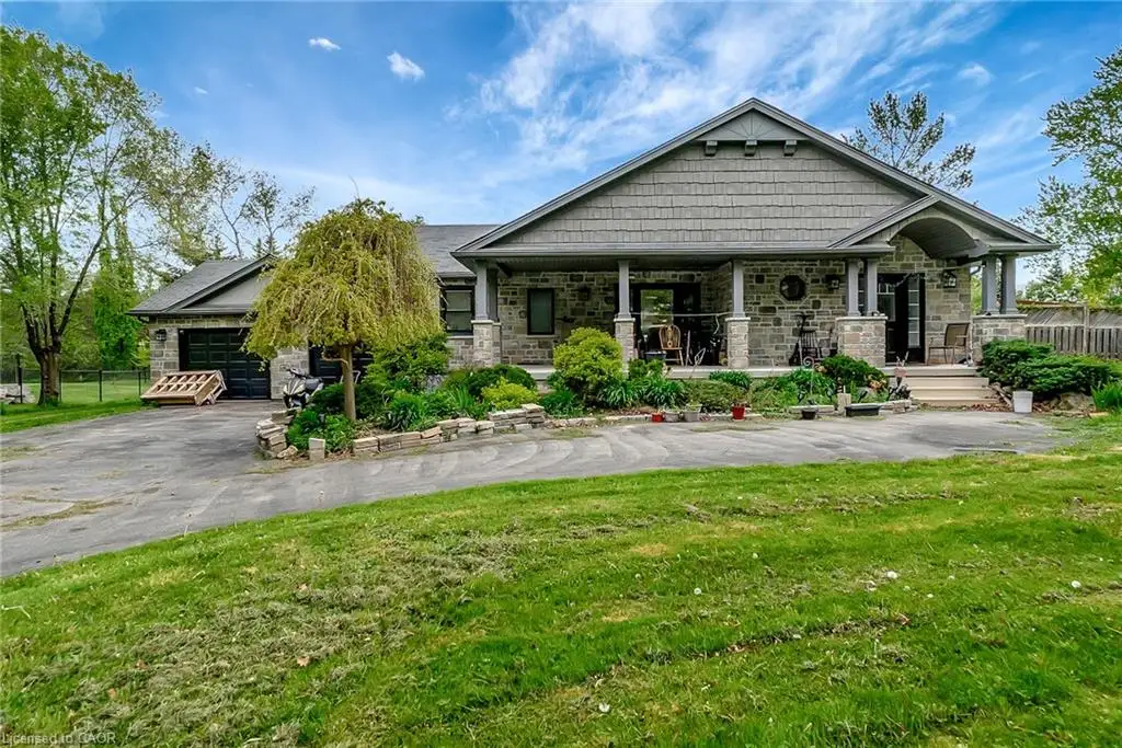 Craftsman house with stone siding, covered porch, and driveway