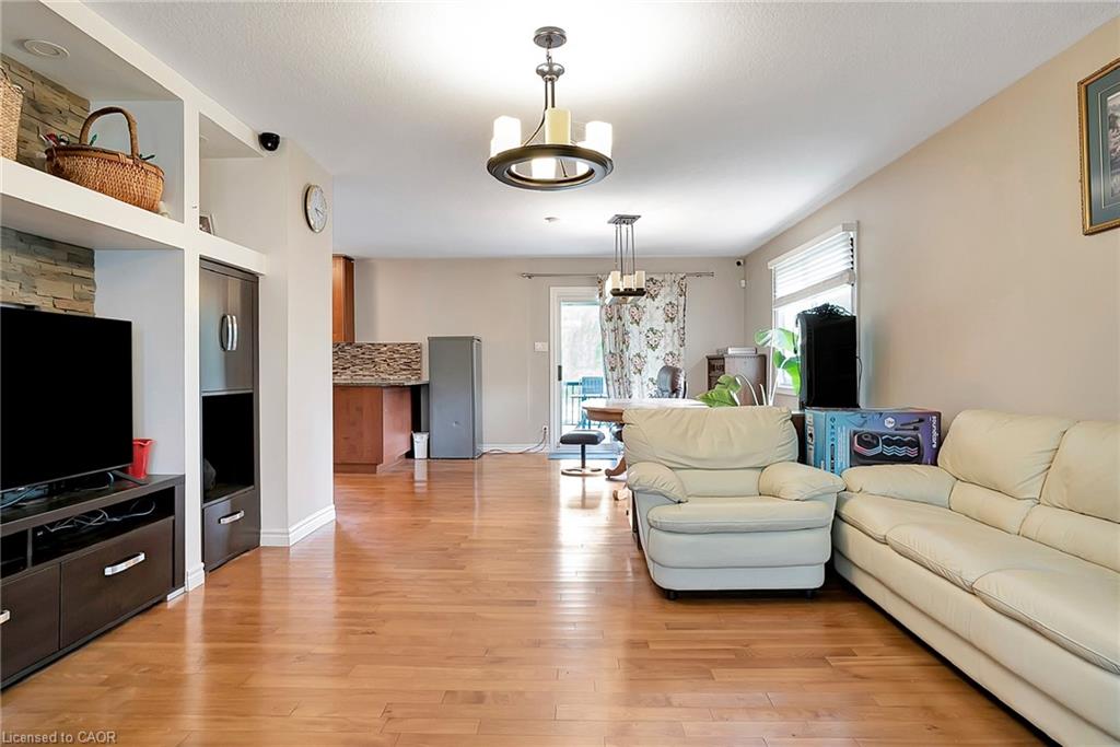 Living area with light wood-style floors, a chandelier, and baseboards