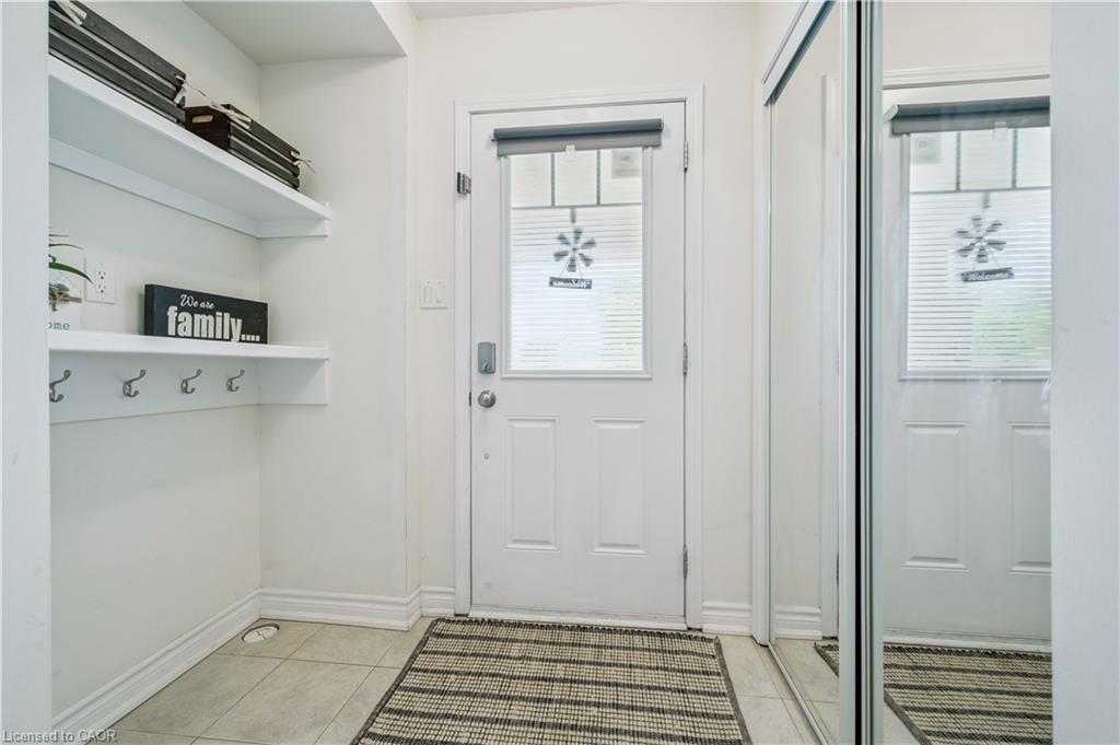 Entryway featuring a white paneled door with an upper glass insert, tile flooring, and a mirrored closet