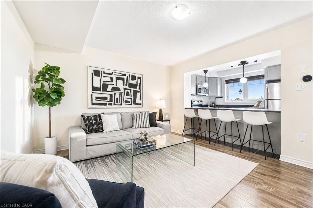 Living area featuring rich wood-finish flooring and a light-toned area rug