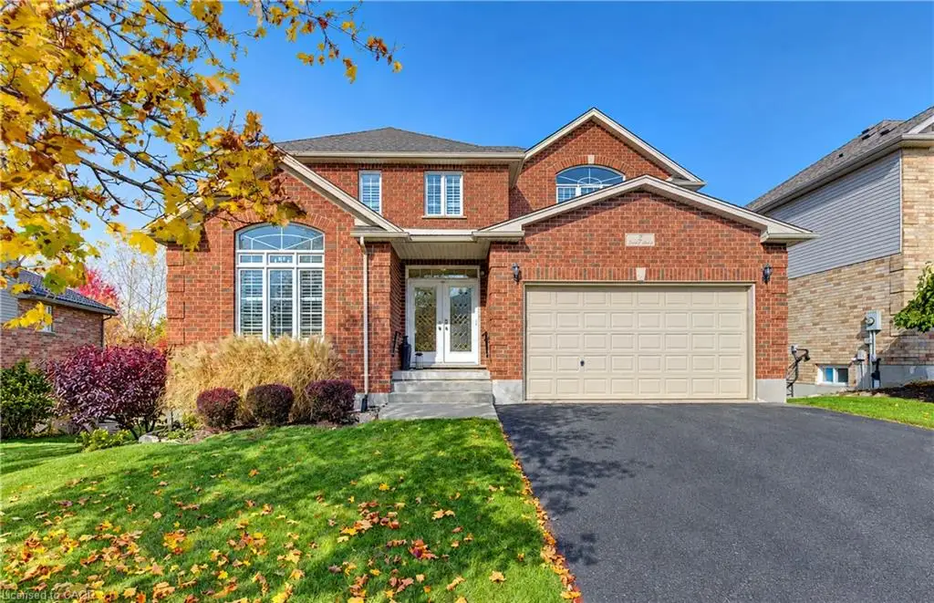 Multi-level brick exterior featuring a double-car garage, arched window accents, and a paved driveway