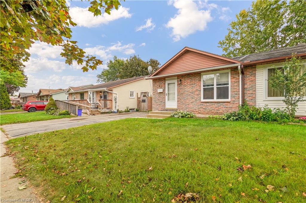 Brick exterior with a peaked roofline, front entry door, and a dedicated driveway