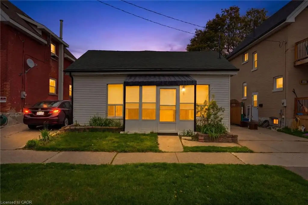 White siding exterior with a dark roof and front awning