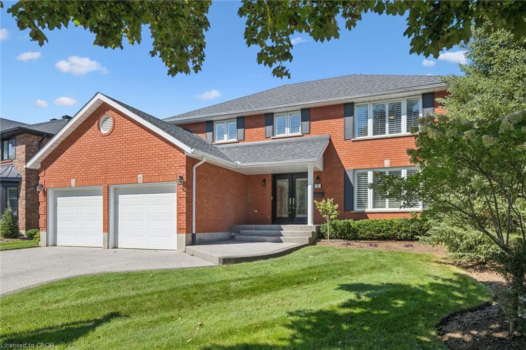 Red brick exterior with a dual garage and dark shutters