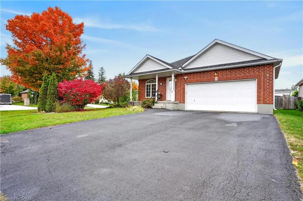Brick exterior facade with a double-gabled roofline, an integrated two-car garage, and an asphalt driveway