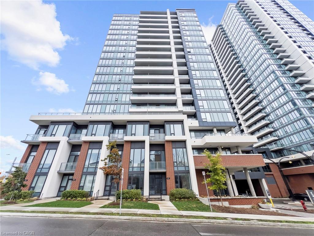 Modern multi-story building featuring extensive glass curtain walls, individual balconies, and brick-clad architectural elements