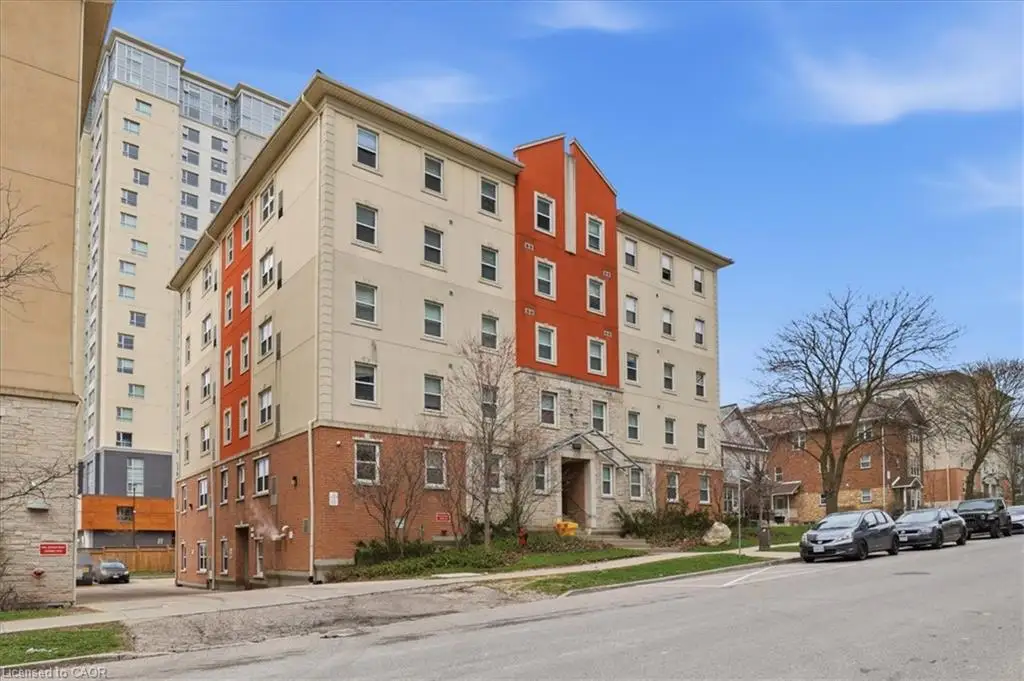 Multi-story building exterior featuring a mix of brick, stone, and stucco facade with a prominent orange architectural accent