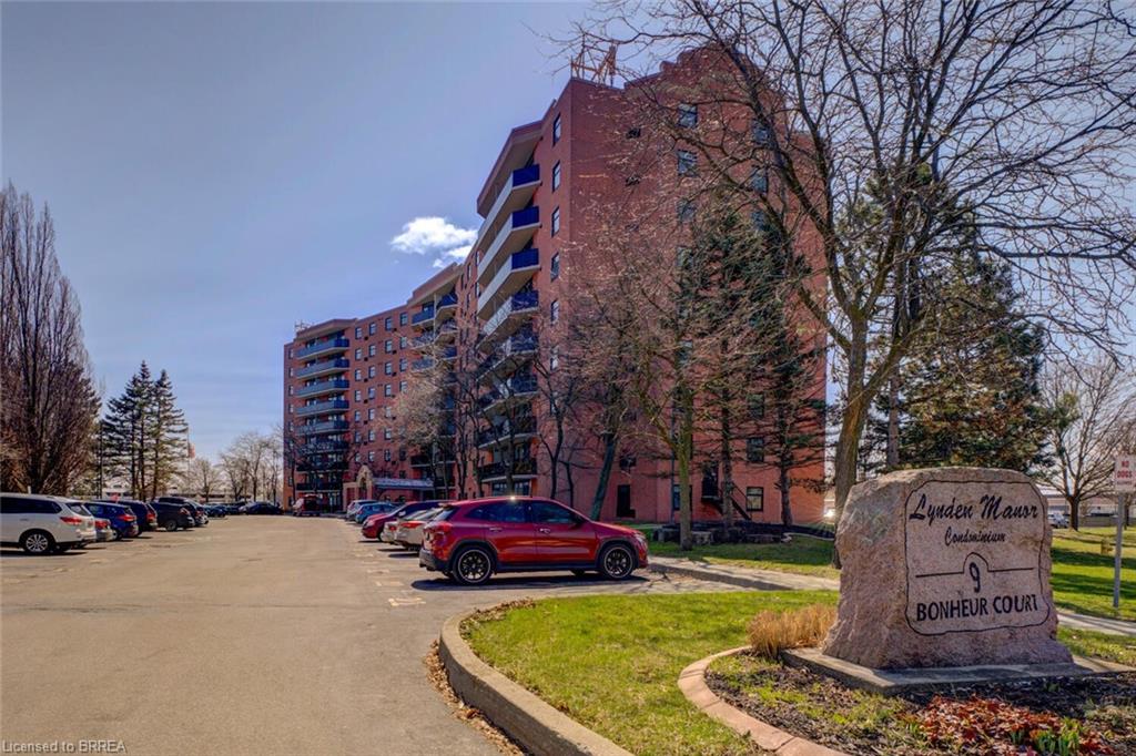 View of apartment building / complex with uncovered parking