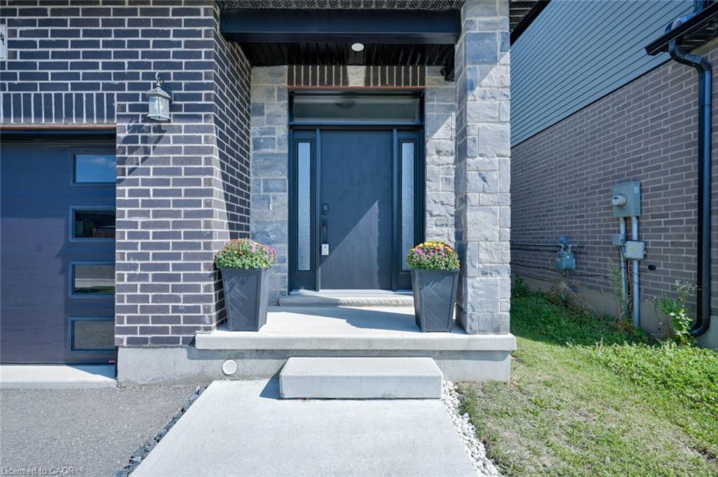 Black brick exterior with stone accents, featuring a contemporary front door with sidelights