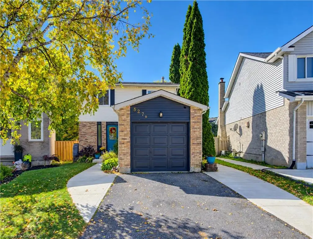 Two-story exterior featuring horizontal siding, brick masonry, an attached single-car garage and concrete walkways