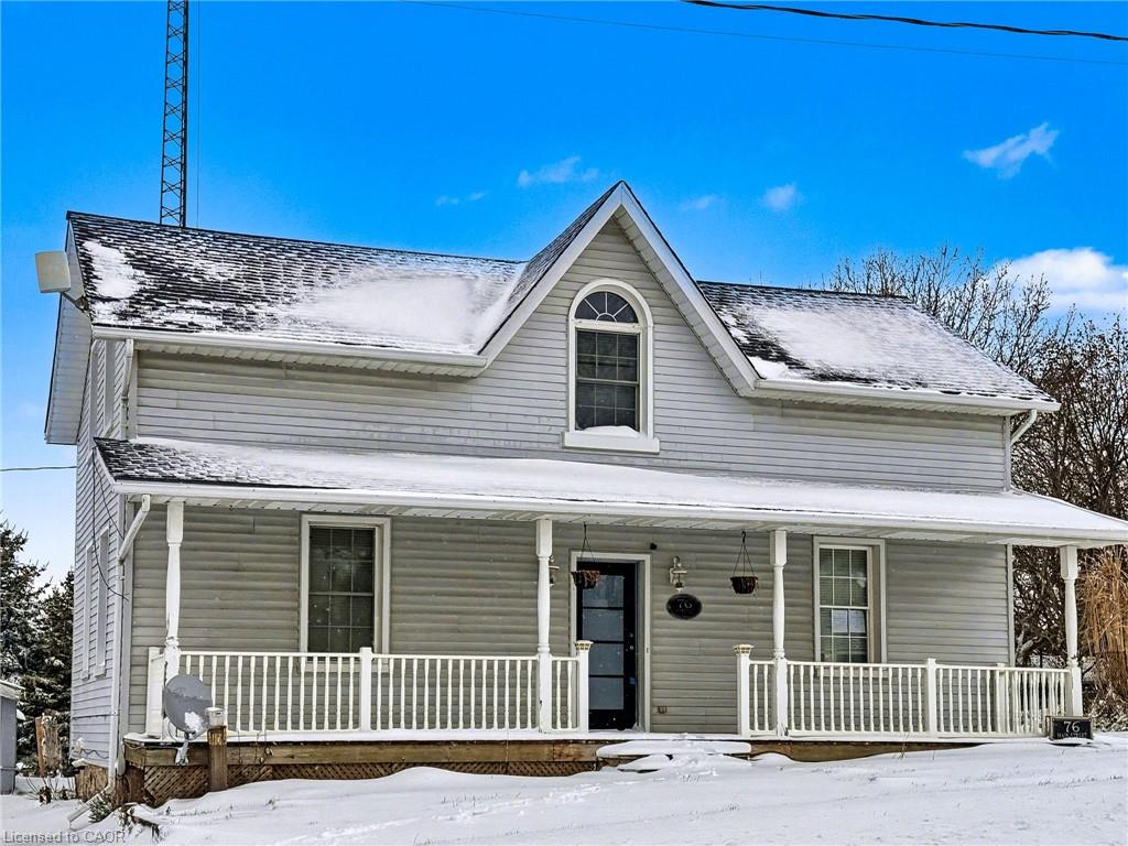Traditional home featuring a covered front porch with white railing, light gray siding, and a dark asphalt shingle roof