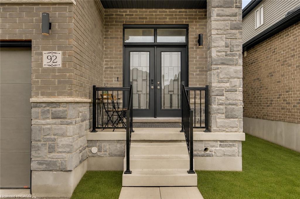 Brick and stone facade featuring double entry doors with decorative glass inserts