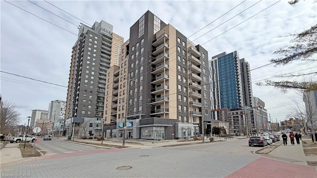 Modern high-rise residential building featuring a dark brick facade and multiple private balconies