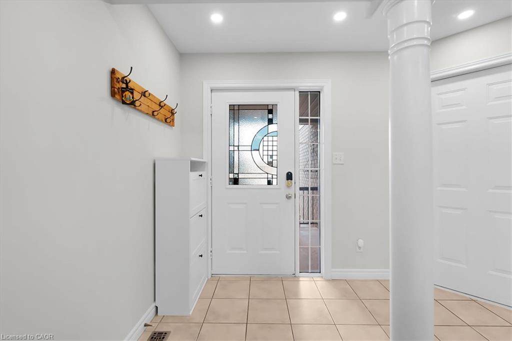 Bright entryway featuring ceramic tile flooring, recessed ceiling lighting, and a white entry door with decorative glass panel