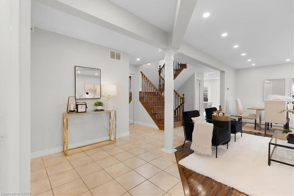 Bright, open foyer featuring coffered ceiling details, recessed lighting, and tile flooring