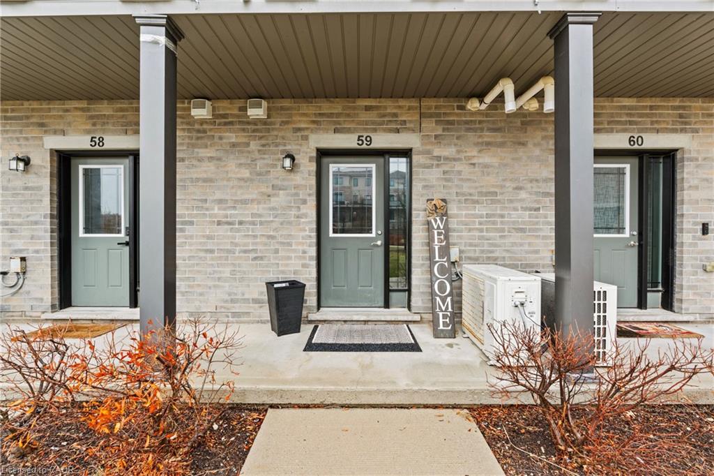 Doorway to property featuring covered porch and brick siding