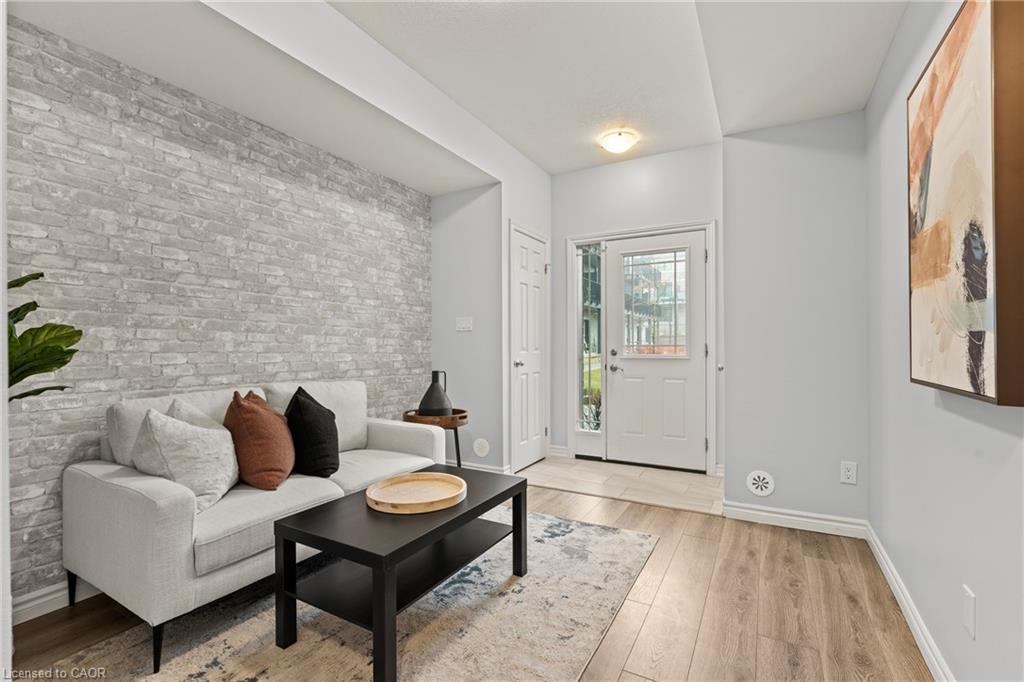 Living room with light wood finished floors and brick wall