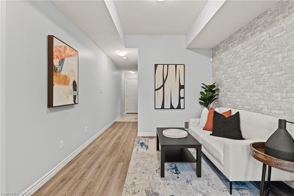 Living area with light wood finished floors and brick wall