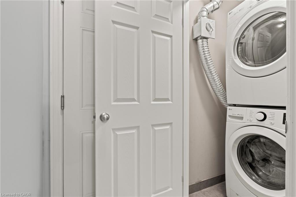 Laundry area featuring baseboards and stacked washing machine and dryer
