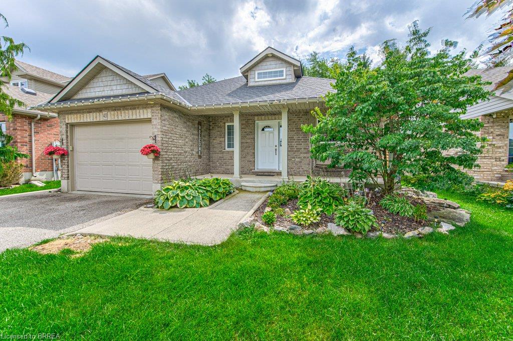 Brick exterior with a peaked roofline, front porch, and an attached garage with a paved driveway