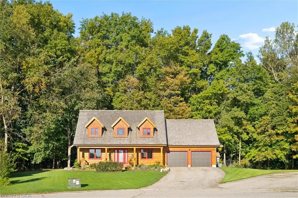 Log cabin exterior with a shingle roof and three dormer windows