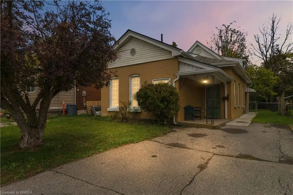 Brick exterior featuring a covered front porch, asphalt driveway, and gabled roofline